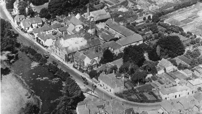 Aerial photograph from 1920s showing allotment gardens on the bend and two of the Brewery Cottages on the right which were demolished by a bomb in WWII and never rebuilt. In the 1960s another building was added, set back behind the remaining cottages and designed to look Victorian. Known as 'Coopers Cottage' this reminds us of an early skilled  trade within the brewery - that of making wooden barrels.